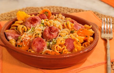 MACARRÃO NA PANELA DE PRESSÃO COM LINGUIÇA SUÍNA servido em um prato de barro.