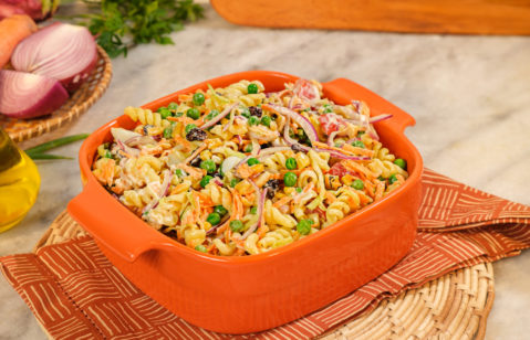 Na imagem há um prato com uma salada de macarrão com legumes e presunto, chamada de macarronese.