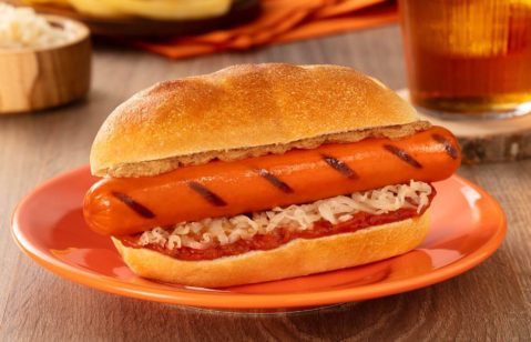 salsicha frankfurt em uma tabua de madeira com molho