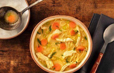 Pote com deliciosa e colorida sopa de legumes com frango.