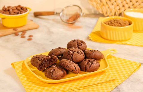 Cachorro-quente servido no pão de alho crocante, recheado com salsicha e coberto com vinagrete colorido de tomate, cebola e ervas frescas.