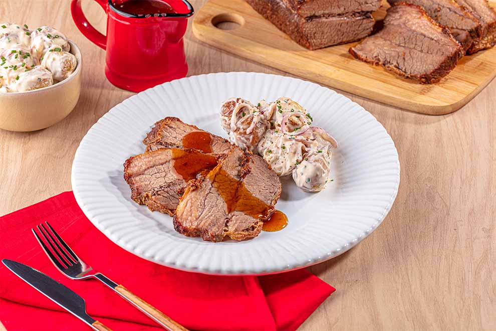 Prato de carne assada com molho e acompanhamento
