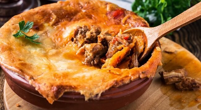 Torta de carne suculenta em prato de barro