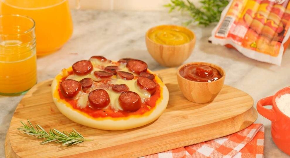 Pizza com salsicha e molhos ao lado
