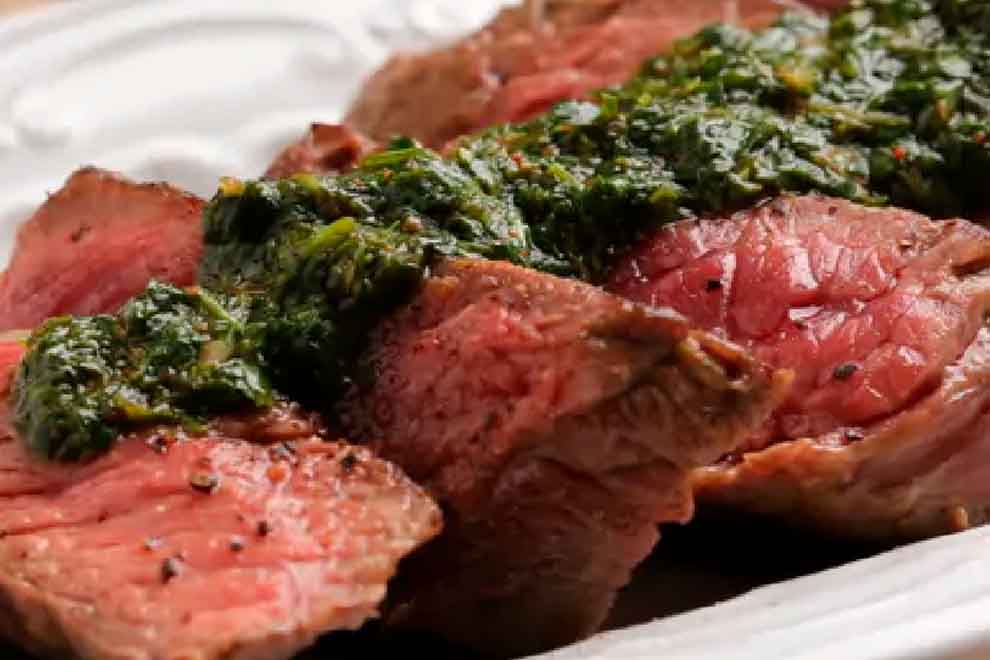 bife ancho ao molho chimichurri e alho frito dentro de uma travessa retangular de porcelana branca