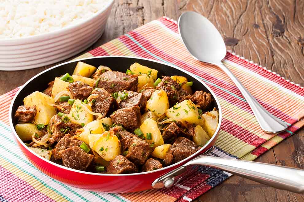 Carnes de segunda são opções mais acessíveis, mas que oferecem sabores incríveis quando preparadas com cuidado. Esses cortes, como acém, coxão duro e músculo, são muito versáteis e podem se transformar em verdadeiras estrelas na cozinha. Com criatividade e técnicas simples, é possível transformar essas carnes em refeições dignas de um banquete.
Além de serem mais econômicas, as carnes de segunda permitem uma variedade de temperos e acompanhamentos. Seja em pratos do dia a dia ou em receitas especiais para surpreender a família, esses cortes oferecem um potencial muito bom. Aproveite as receitas a seguir:
1. Acém com cebola e batatas
Prepare um prato simples e delicioso combinando acém, cebola e batatas. O acém, uma carne suculenta, ganha destaque ao ser cozido com cebolas macias e batatas que absorvem todo o tempero. As cebolas trazem um toque adocicado, enquanto as batatas completam a refeição com sua textura cremosa.
Essa combinação é perfeita para um almoço em família, acompanhada de arroz branco ou pão fresquinho. A simplicidade dos ingredientes transforma-se em uma experiência gastronômica aconchegante, ideal para quem busca um prato prático e delicioso.
2. Picadinho de carne coxão duro
O picadinho de coxão duro é um clássico que não pode faltar na cozinha brasileira. A carne, cortada em pequenos cubos, é temperada e cozida até alcançar o ponto ideal, onde fica macia e envolvida por um molho encorpado e aromático. Ingredientes como tomate, cebola e ervas frescas trazem camadas de sabor, transformando o prato em algo simples e especial.
Servido com arroz soltinho, feijão temperado e uma farofa crocante, o picadinho se torna uma refeição equilibrada, nutritiva e cheia de afeto. É perfeito para os dias em que se busca uma comida que reconforta e enche de energia.
3. Coxão duro com ratatouille
Transforme o coxão duro em um prato sofisticado ao combiná-lo com um ratatouille de legumes. A carne, temperada e cozida lentamente, fica macia e absorve os sabores dos vegetais frescos, como abobrinha, berinjela, cenoura e tomate. O ratatouille complementa a carne com seu frescor, textura e cores vibrantes, criando um prato equilibrado e visualmente atrativo.
Essa receita é ideal para jantares especiais ou para quem deseja experimentar algo novo sem perder o toque caseiro. Harmonize com um purê de batatas cremoso, arroz integral ou cuscuz marroquino para uma refeição cheia de personalidade e sabor.
4. Croquete saboroso de coxão duro
Os croquetes de coxão duro são uma solução criativa e deliciosa para aproveitar sobras de carne. Após serem empanados e fritos, os croquetes ficam dourados e crocantes por fora, com um recheio macio e cheio de sabor por dentro.
Eles são versáteis e podem ser servidos como petisco, acompanhamento ou até mesmo como parte principal de uma refeição mais descontraída. Combinam bem com molhos variados, como mostarda ou maionese temperada, agradando a todos os paladares.
5. Músculo na pressão
O músculo cozido na panela de pressão é um verdadeiro abraço em forma de comida. Essa carne, conhecida por seu sabor intenso, ganha maciez ao ser cozida lentamente, liberando um caldo rico e cheio de aromas. Ingredientes como tomates, cenouras e cebolas complementam o prato, formando um molho encorpado que valoriza ainda mais a carne.
O músculo é extremamente versátil e combina bem com acompanhamentos como purê de mandioca, polenta cremosa ou até mesmo legumes assados. É uma escolha ideal para refeições que pedem conforto e sabores marcantes, sendo capaz de agradar em qualquer ocasião.
6. Ensopado de músculo com batatas
O ensopado de músculo com batatas é um prato que traduz aconchego e tradição. Cozido lentamente, o músculo adquire uma textura macia e suculenta, enquanto as batatas, cenouras e tomates criam um caldo espesso e cheio de sabor. As ervas e especiarias acrescentam camadas de aroma, transformando cada colherada em uma experiência reconfortante.
Perfeito para dias frios ou quando se busca uma refeição completa, o ensopado harmoniza muito bem com arroz soltinho, pão caseiro ou até mesmo uma porção de polenta. É uma receita clássica que une a simplicidade e o prazer de uma boa comida caseira.
7. Costela na panela de pressão
A costela preparada na panela de pressão é uma celebração de sabor e maciez. Quando cozida adequadamente, a carne se desprende do osso com facilidade, oferecendo uma textura suculenta e irresistível.
O caldo formado pelo cozimento, enriquecido com cebolas, tomates e um toque de páprica, é um verdadeiro convite para mergulhar pedaços de pão ou regar os acompanhamentos.
Para completar a refeição, sirva com mandioca cozida, arroz branco ou uma salada leve. Esse prato é uma escolha certeira para almoços especiais, jantares em família ou qualquer ocasião onde o sabor precisa ser o protagonista.
Viu só? Receitas com carne de segunda mostram que é possível economizar sem abrir mão do sabor. Experimente as sugestões e descubra novas maneiras de transformar cortes simples em pratos especiais. Ah, e para mais dicas e informações sobre como aproveitar ao máximo esses cortes, confira nosso conteúdo sobre qual é a carne de segunda mais macia. Até a próxima!