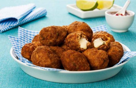 O lanche buraco quente é visto em porções individuais: pães com cavidade preenchida por carne moída e finalizados com cheiro-verde, servidos em uma cesta.