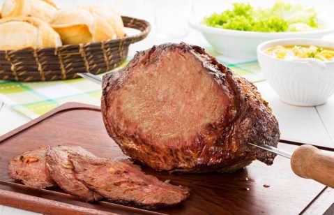 Prato de carne assada com molho e acompanhamento