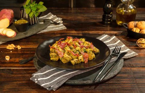 Prato de nhoque com bacon e molho verde.