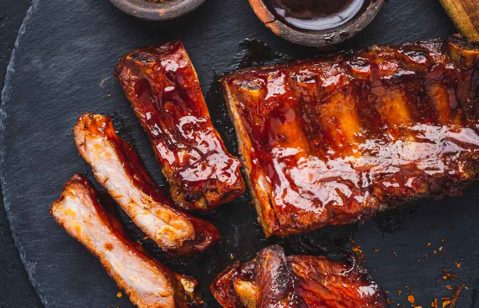 costela barbecue em cima de uma tábua de madeira escura