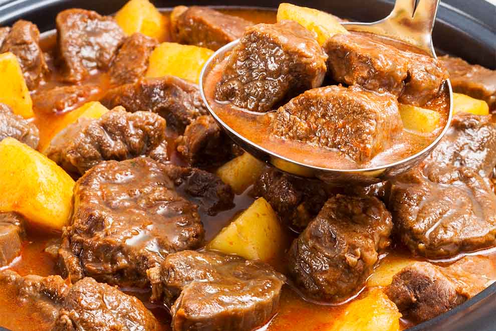 ensopado de músculo com batata dentro de uma panela com uma concha dentro