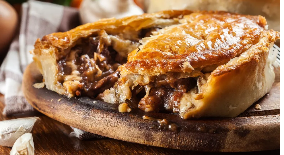Torta de carne suculenta e crocante em uma tábua de madeira