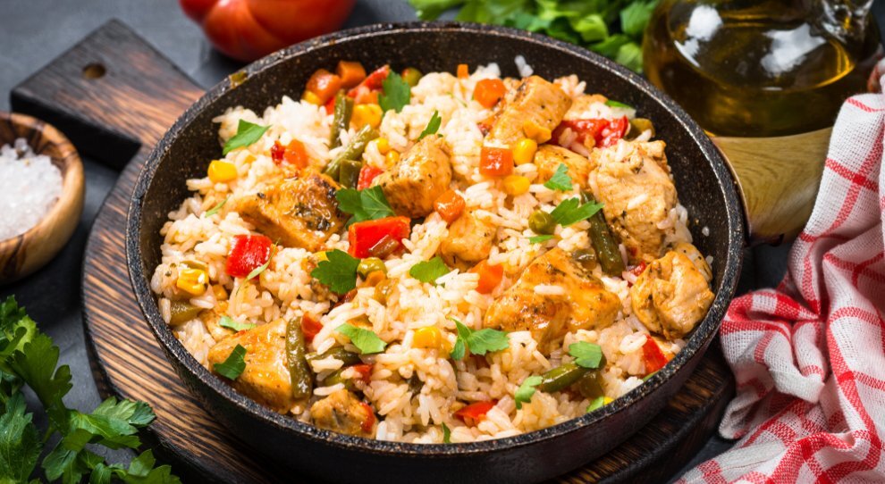 Arroz com frango e vegetais em uma panela de ferro